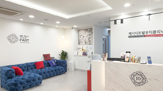Reception desk and waiting area with blue sofa at JD Clinic
