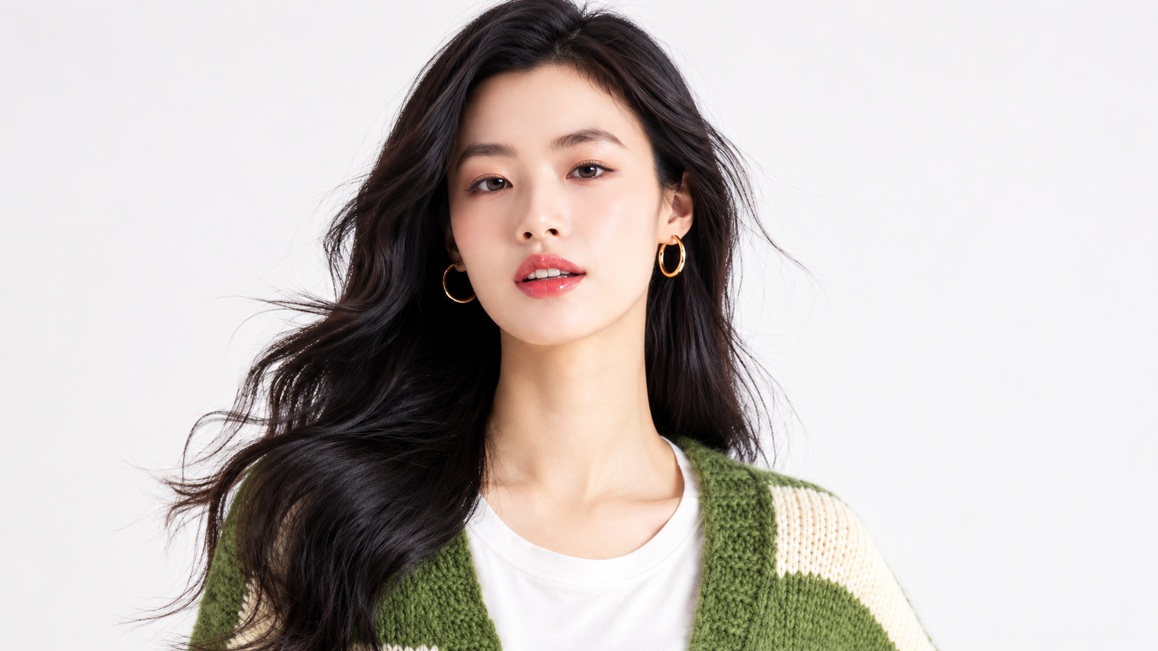 Model in a green knit cardigan facing the camera to illustrate clear, healthy skin