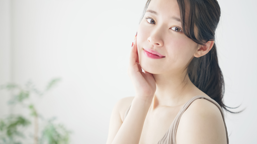 Model resting her cheek in her palm to show soft, moisturized skin