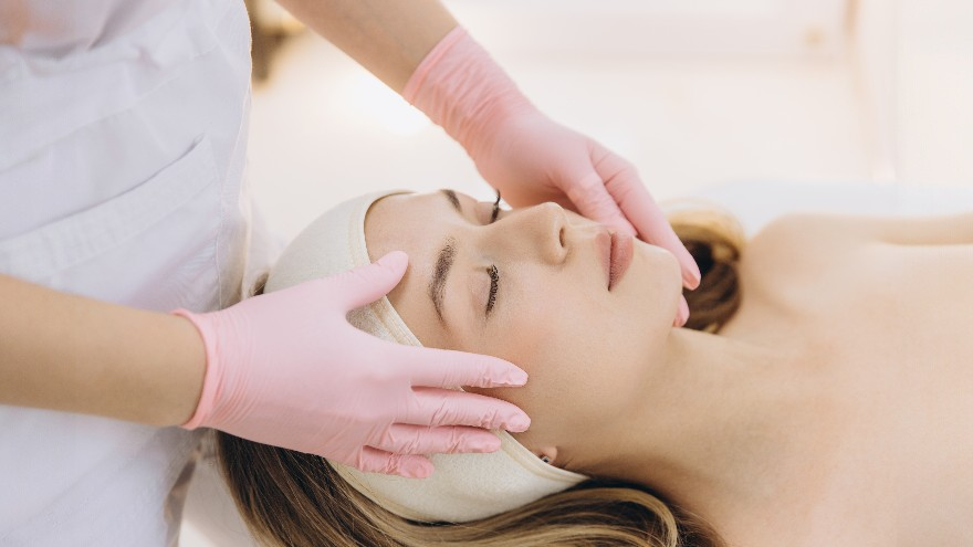 Practitioner performing a facial massage on a patient's forehead and cheeks