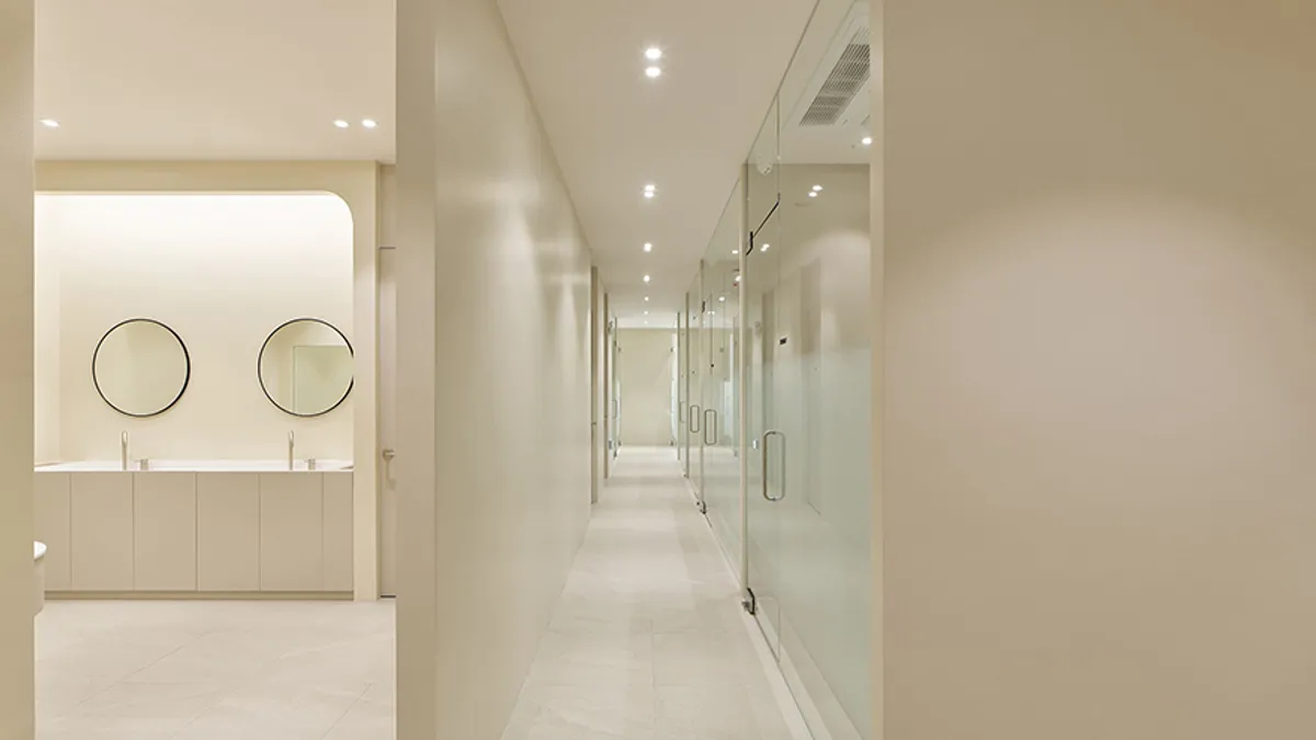 dermatology clinic interior with a clean hallway, round mirrors, and a modern powder room area