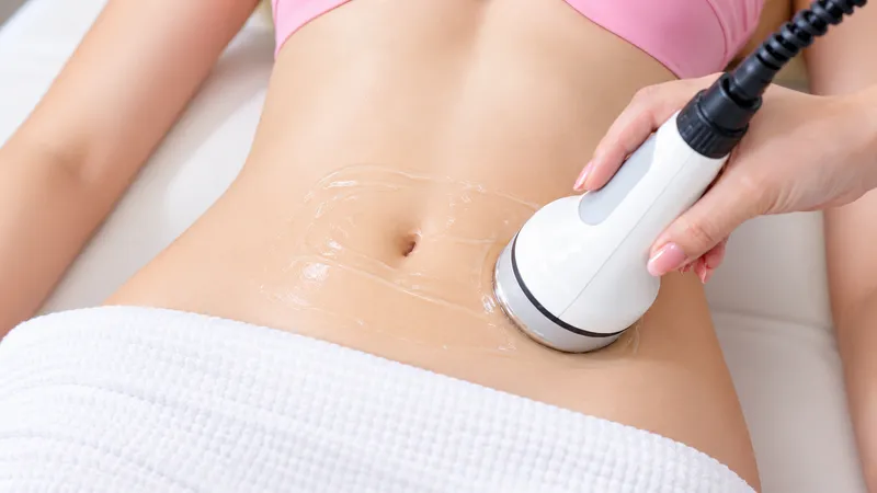 Practitioner using a handheld device on a woman’s abdomen.