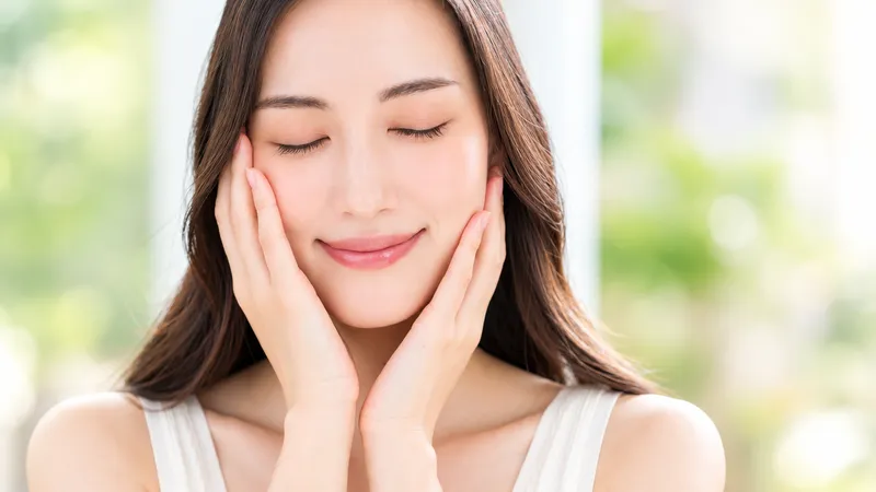 女性閉上雙眼，雙手輕觸臉頰。