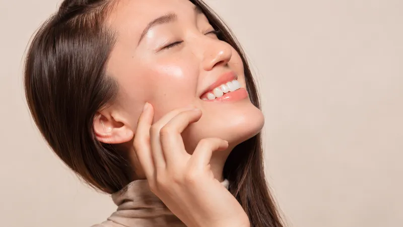 Smiling woman with dark hair against a light background.