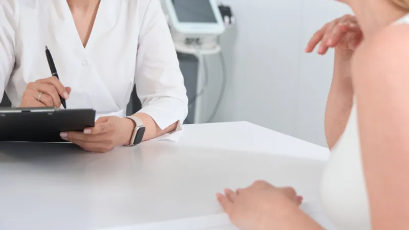 Doctor discussing non-surgical facial lifting treatment options with a patient during a consultation.