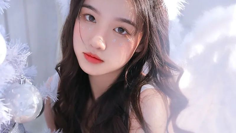 在白色装饰枝条旁摆姿势、留着深色长发的女性。