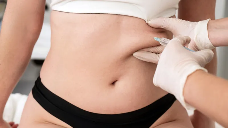 Practitioner administering an injection to a woman’s abdomen.