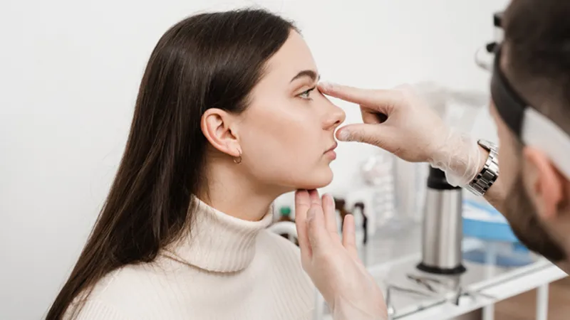Doctor assessing a patient’s nose during a consultation for nose filler treatment.