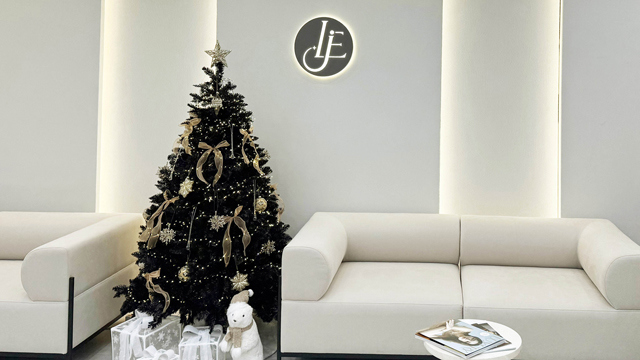 Waiting area at Le.J Plastic Surgery with white seating and a Christmas tree.