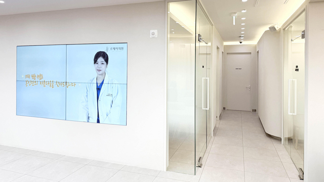 Hallway at Le.J Plastic Surgery with glass treatment room doors.
