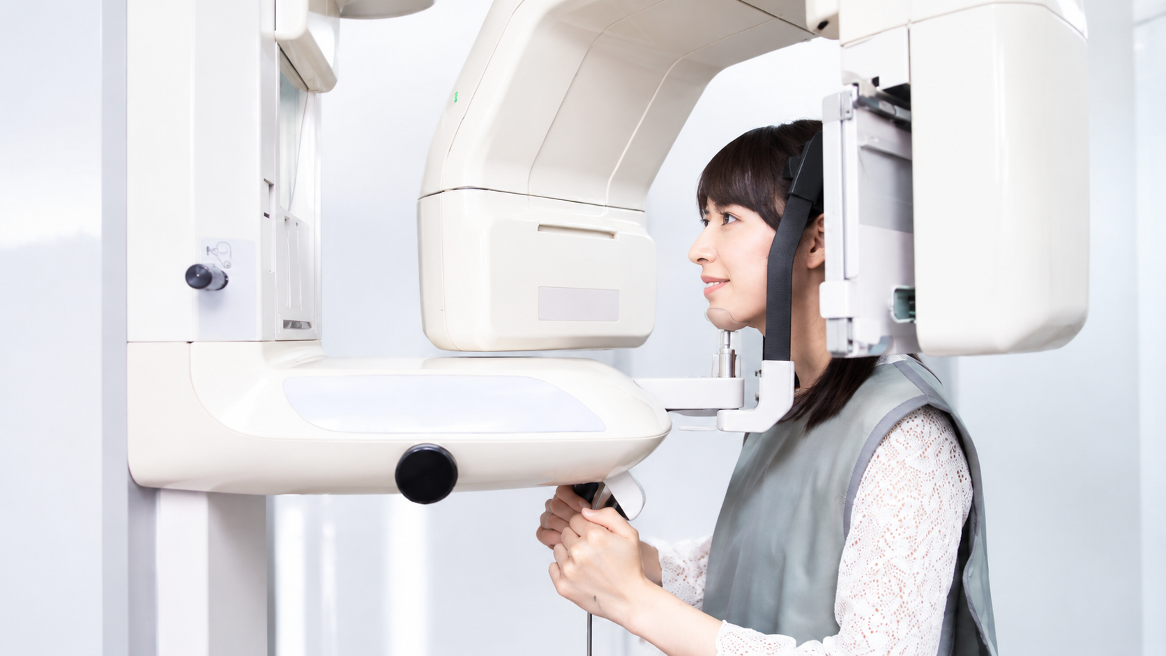 Woman positioned in a facial imaging machine for diagnostic scanning.