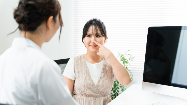Patient consulting with a doctor about rhinoplasty treatment options.