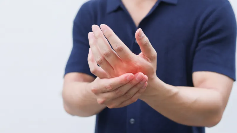 Doctor examining a patient’s hand to assess tremor during a neurological evaluation.